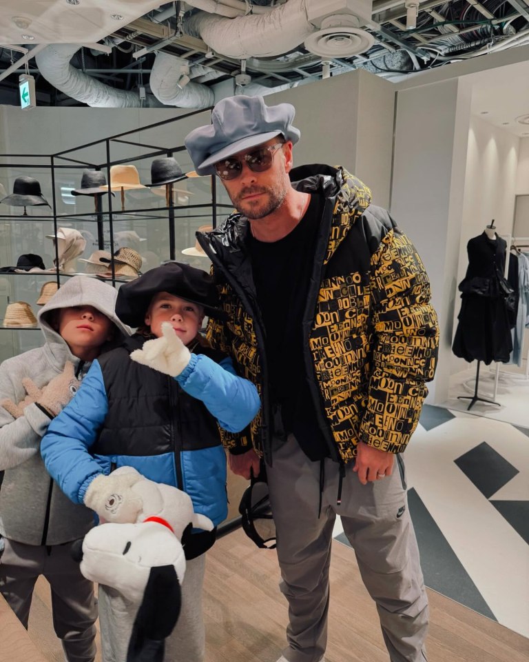 Chris Hemsworth with his two sons in a hat shop.