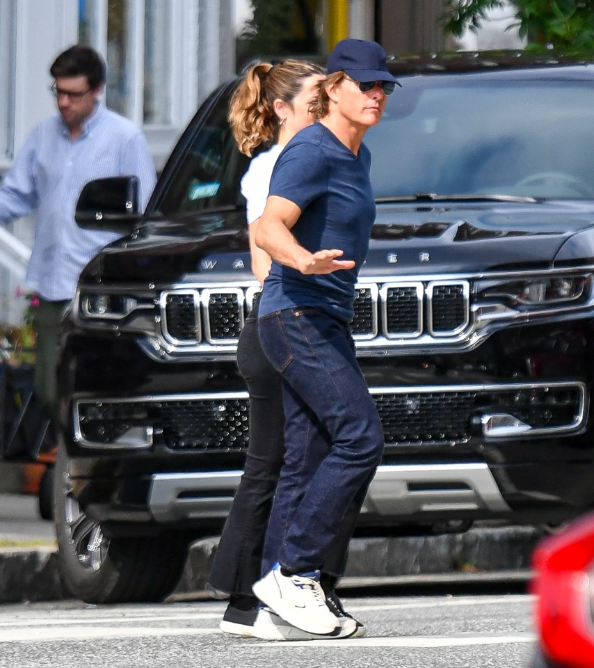 Tom Cruise and Ana de Armas holding hands while walking.