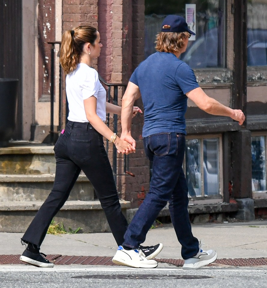 Tom Cruise and Ana de Armas holding hands while walking.