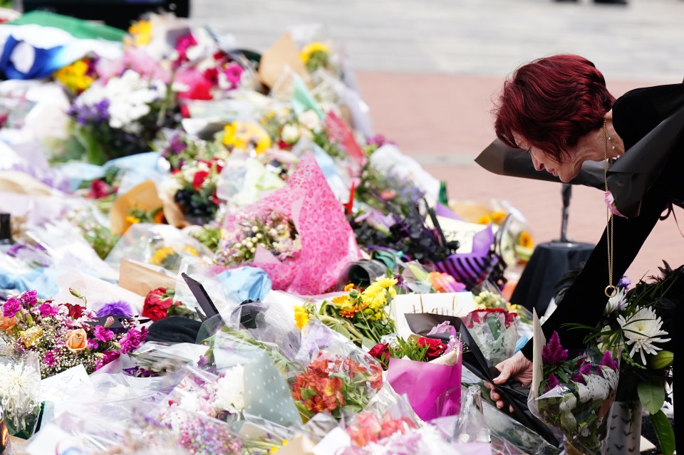 Sharon Osbourne placing flowers at a memorial.