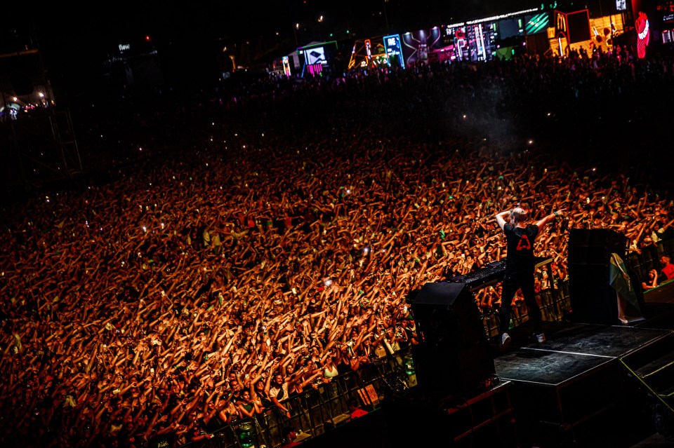 Armin van Buuren performing at a concert to a large crowd.