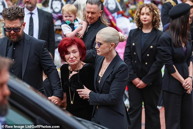 Kelly wraps her arm around her mother, as both she and Jack support her on the way back to their car