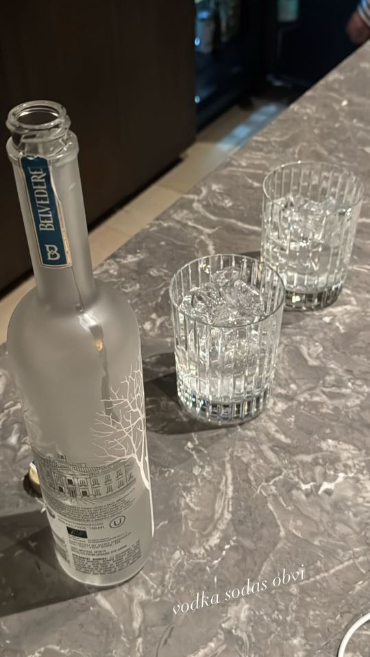 A bottle of Belvedere vodka and two glasses with ice.