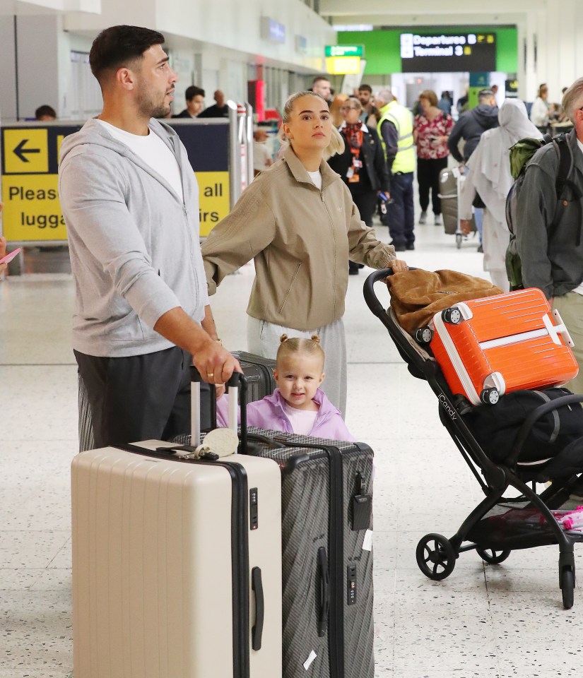 Molly-Mae Hague, Tommy Fury, and their daughter at an airport.