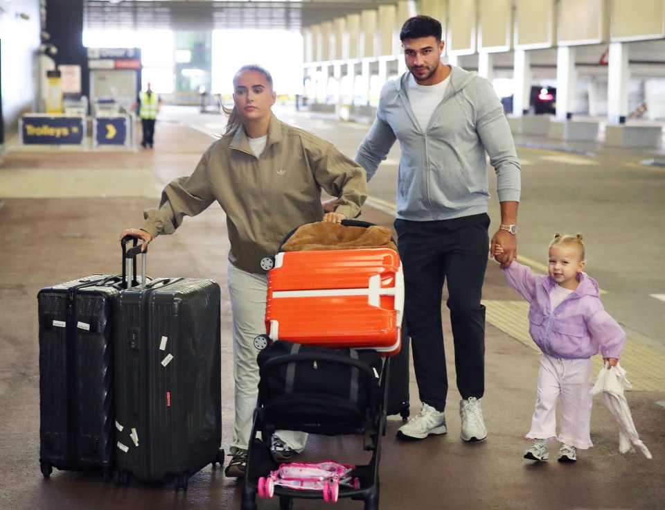 Molly-Mae Hague, Tommy Fury, and their daughter at an airport.