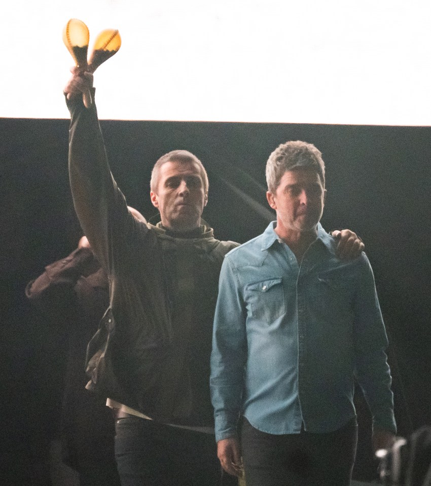 Liam Gallagher and Noel Gallagher of Oasis at a concert.