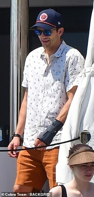The 47-year-old venture capitalist sported a white-patterned short-sleeve button-up, orange shorts, and white slip-on shoes