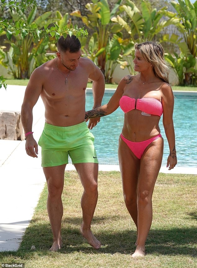 The pair held hands as they walked around the swimming pool