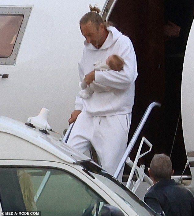 The Australian restaurant mogul was instantly recognisable as he stepped out of his private jet with his long hair slicked back into a bun