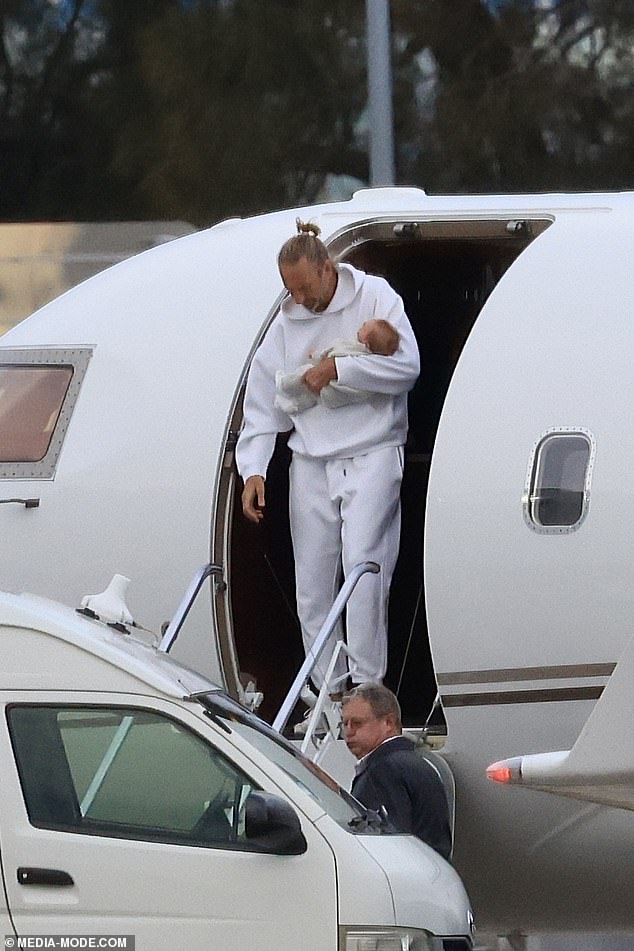 Justin Hemmes (pictured) was every inch the doting dad as he arrived back in Sydney from an overseas holiday with his newborn son and girlfriend Madeline Holtznagel