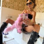 Kate Beckinsale left her fans baffled on Tuesday when she posed with her dyed pink cat in a series of racy photos