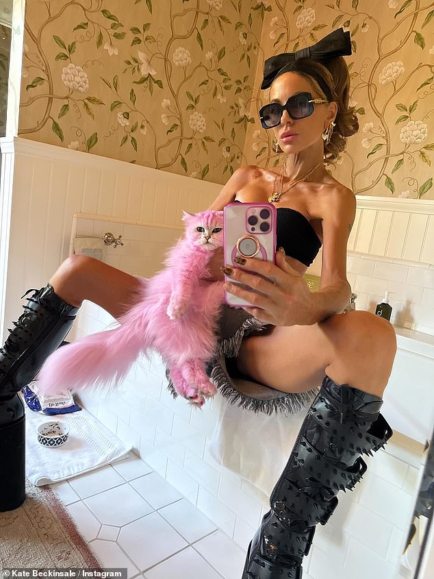 Kate Beckinsale left her fans baffled on Tuesday when she posed with her dyed pink cat in a series of racy photos