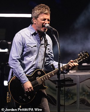 The Oasis brothers Noel and Liam Gallagher walked out on stage holding hands for night two of their long-awaited reunion tour in Cardiff (Noel Gallagher pictured on stage Friday)