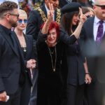 Ozzy Osbourne's tearful widow Sharon Osbourne is pictured yesterday giving a peace gesture to fans