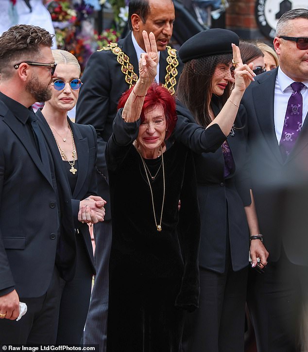 Ozzy Osbourne's tearful widow Sharon Osbourne is pictured yesterday giving a peace gesture to fans