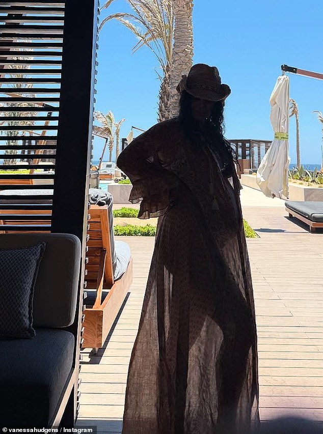 A silhouetted image showed the beaming beauty in a long, sheer cover-up