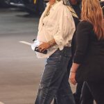 Pregnant Rihanna covered up her growing baby bump with a white button-up shirt and jeans while running errands in Beverly Hills on Friday